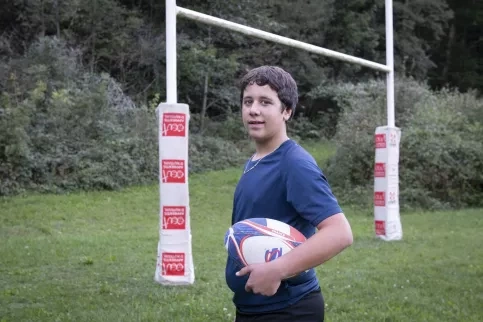  IES Saint-Paul - Jordan (3ème) pose avec un ballon de rugby
