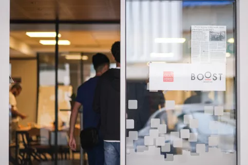 Jeunes entrant dans une pièce sur la porte de laquelle un panneau "Boost Insertion" est apposé